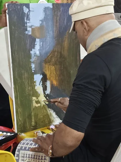 A view from behind my easel during a live landscape painting demonstration. This perspective shows the tools of my trade, from the palette of acrylics to the various brushes I use to achieve different effects.