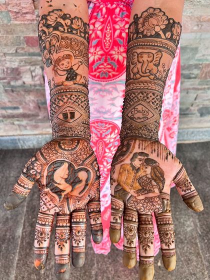 A stunning baby shower mehendi with a rich, dark stain. The design features portraits of the expecting couple and a silhouette of a mother and child.
