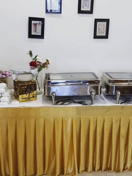 A simple yet elegant buffet setup for 25 guests, using a gold table skirt and tasteful decor.