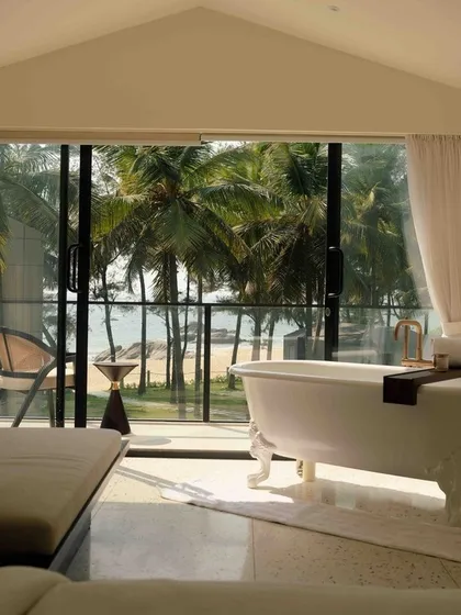 A luxurious bathtub with a view of the ocean and palm trees at The Postcard Arabian Sea. It's the ultimate in relaxation and coastal luxury.