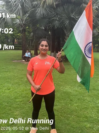 A female member after a 25km Independence Day run, holding the flag. Her dedication to both running and her country is inspiring.