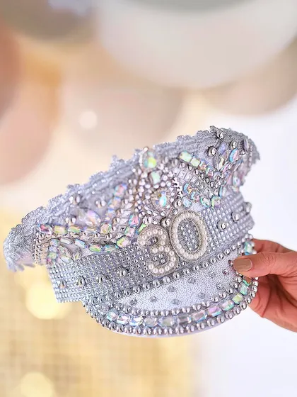 A stunning, custom-made captain's hat covered in jewels and pearls for a 30th birthday, a perfect accessory for the guest of honor.