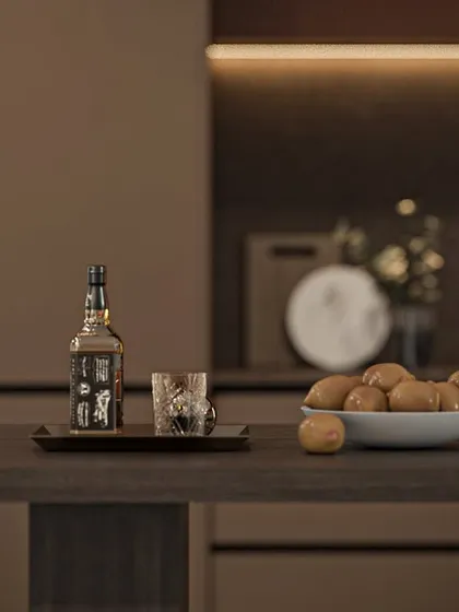 The kitchen island doubles as a casual dining or serving space. The dark wood finish of the breakfast counter extension complements the overall color scheme.