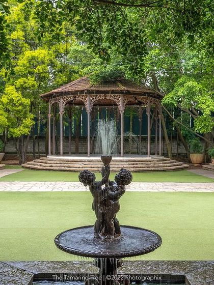 The Colonial Bandstand and its manicured lawn, viewed from across the central fountain, a picture of colonial-era grandeur.