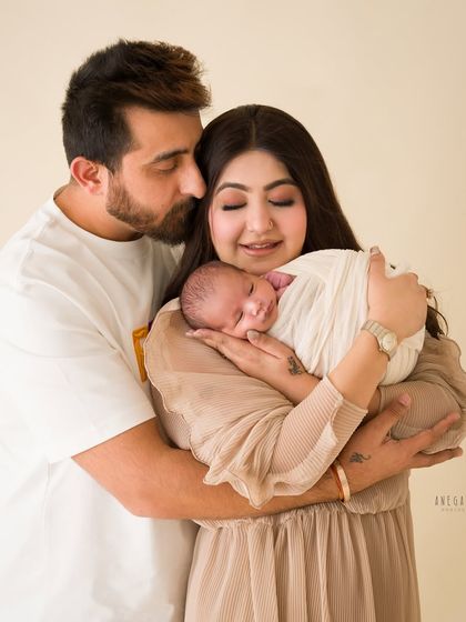 A quiet moment of connection between parents and their newborn. The way they hold their baby together shows a world of love and tenderness. This is a classic family newborn portrait.