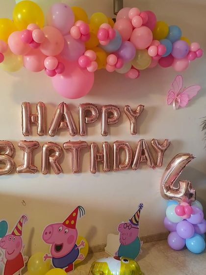 A simple and sweet Peppa Pig theme for a 4th birthday at home, with character cutouts and a colorful balloon cloud.