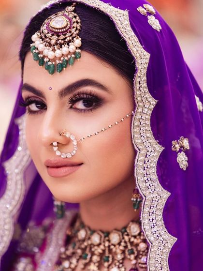 An intense and beautiful close-up of the Sikh bride, showcasing her maang tikka and the edge of her floral bun.
