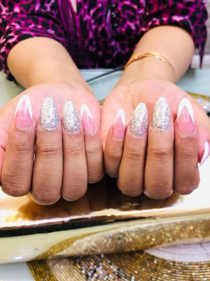 A glamorous take on the French manicure, combining a sharp V-tip with full-coverage silver glitter on the accent nails.