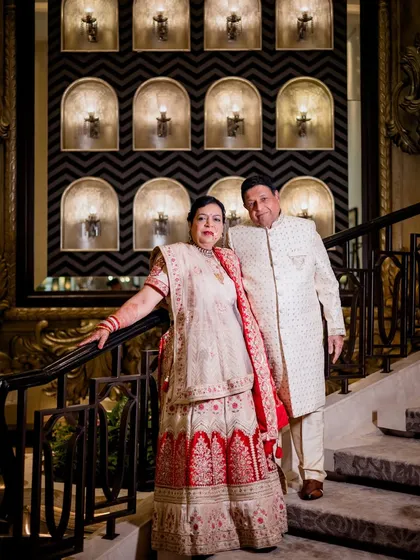 A classic portrait of the couple on the grand staircase during their 50th-anniversary celebration, looking regal and happy.