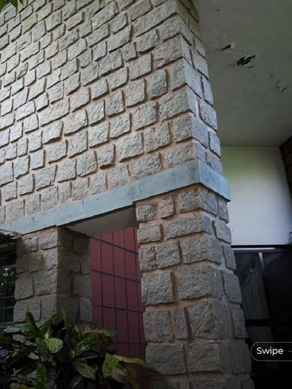 A detail of the stonework at the Rehmat Tarikere Residence, showing the craftsmanship and the timeless quality of the natural material.