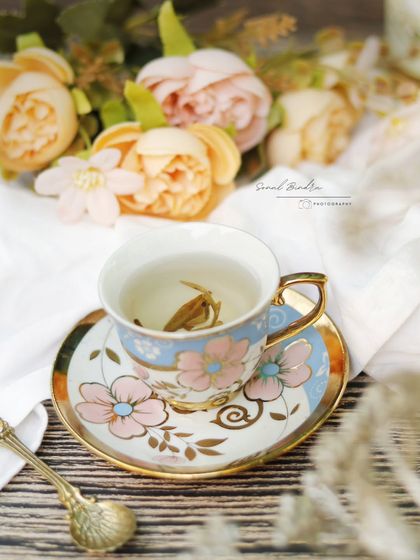 This frame is about the feeling of pausing to savor something delicate. A single jasmine pearl unfurls in a vintage-style teacup, surrounded by soft florals, creating a poetic and beautiful moment.