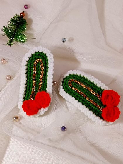 Vintage-style Christmas hairclips with a green base, gold thread detail, and a tiny red bow.
