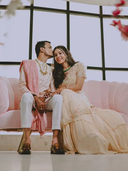 A beautiful portrait of the newly engaged couple, capturing a tender moment on a modern pink sofa.