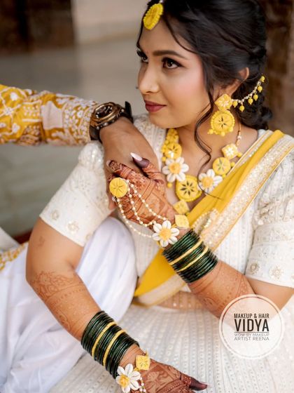 A close-up of Priya's haldi look, showing her beautiful floral jewellery and the soft, natural makeup by Vidya.