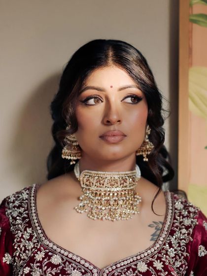 The winged eyeliner and soft waves give Kavi a look of classic, old-world glamour. This style is perfect for brides who want a timeless yet striking appearance.