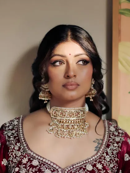 The winged eyeliner and soft waves give Kavi a look of classic, old-world glamour. This style is perfect for brides who want a timeless yet striking appearance.