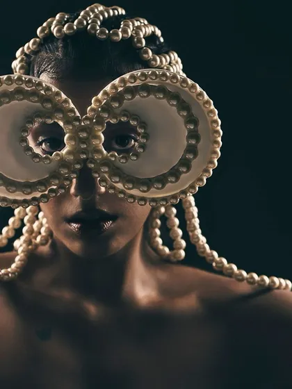 An experimental and artistic portrait where fashion becomes sculpture. This look features a custom-designed headpiece made of pearls, transforming a simple portrait into a conceptual piece of wearable art.