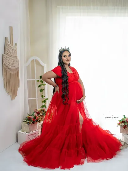 A queen awaiting her heir. Set in my bright, white studio space, this portrait uses a flowing red gown and a delicate crown to create a look of regal elegance.