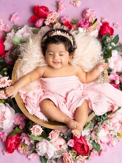 A sleepy, happy baby surrounded by a wreath of pink flowers. This is a beautiful and serene way to capture a three-month milestone.