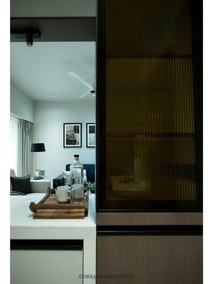 A view from the living room towards the open kitchen at Tulsi Heights. The fluted glass partition on the breakfast bar provides a sense of separation while still allowing light and conversation to flow.