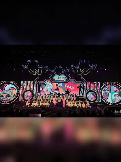 This is the scale we operate on. A full stage view from our award-winning choreography for the WOW Awards Asia 2024, featuring a massive ensemble of dancers, vibrant costumes, and a dynamic LED backdrop. We bring this level of energy to every live event.