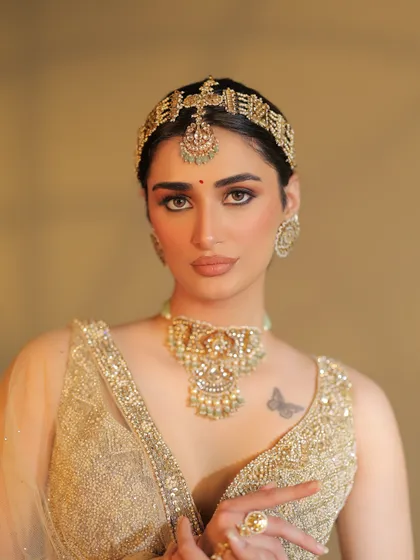 A close-up of the bride's flawless makeup and unique headpiece. The styling is a perfect blend of traditional and contemporary elements.
