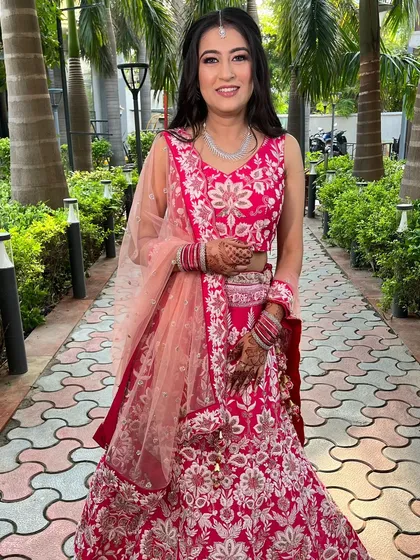 A full-length photo of our client's engagement look. The bright pink lehenga is perfect for a fun, celebratory event.