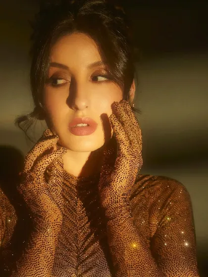 For her appearance on Jhalak Dikhhla Jaa, I put Nora Fatehi in this shimmering, form-fitting gown by Itrh. The ruched fabric and built-in gloves create a sophisticated and high-fashion television look.