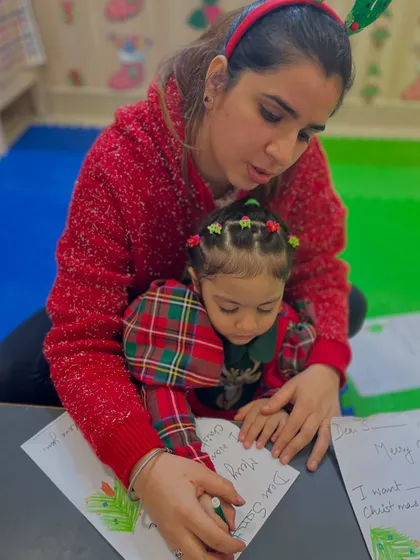 A mother and daughter work together on writing a letter to Santa. Our workshops encourage family participation and creating memories together.