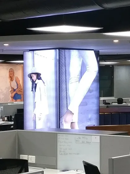 The open-plan office for Skechers features a central column with an integrated digital display. This serves as a dynamic focal point for branding and internal communication, aligning the workspace with the company's culture.