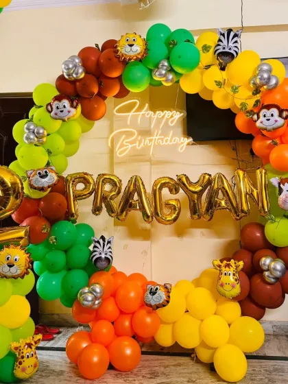 Here is a fun jungle theme birthday decoration I did. The circular ring is filled with a colorful balloon garland, cute animal face foil balloons, and a personalized name in gold, all lit by a "Happy Birthday" neon sign in the center.