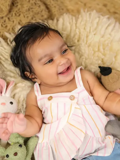 Her smile just lights up the room! Capturing these happy, relaxed moments on a soft rug with her favorite toys is just lovely.