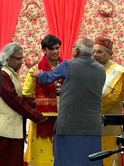 A guru blesses a young performer on stage, a poignant moment of the Guru-Shishya tradition.