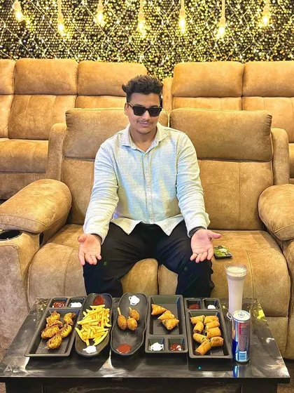 Celebrating turning nineteen with a feast. This guest is ready to dig into a spread of delicious snacks like fries, samosas, and nuggets while enjoying the comfort of my plush recliner seats.