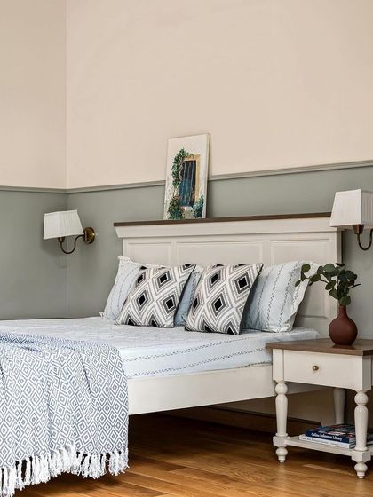 A shot of the parents' bedroom featured in a magazine. The two-tone wall and classic furniture create a serene and timeless space.