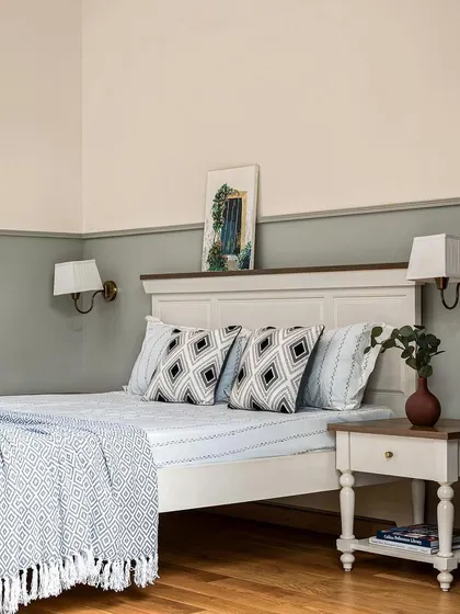 A shot of the parents' bedroom featured in a magazine. The two-tone wall and classic furniture create a serene and timeless space.