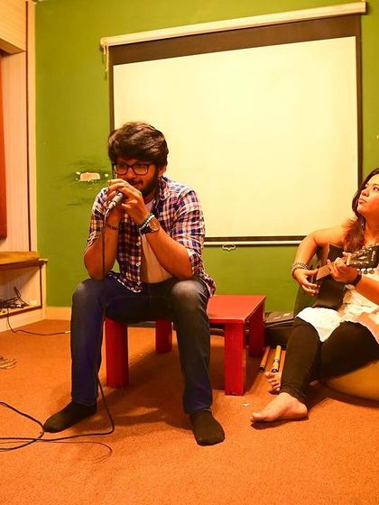 A musician playing the harmonica, accompanied by a ukulele, during one of our intimate and soulful music nights.