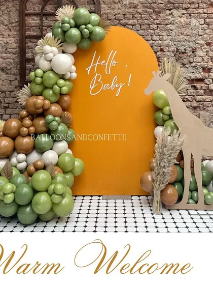 A warm welcome with a modern safari theme. The giraffe cutout filled with balloons is a creative and eye-catching element.