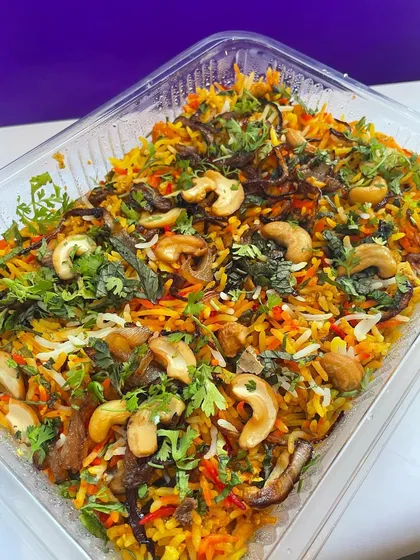 A party-sized container of my flavorful vegetable biryani, loaded with cashews and fried onions. Perfect for bulk orders.