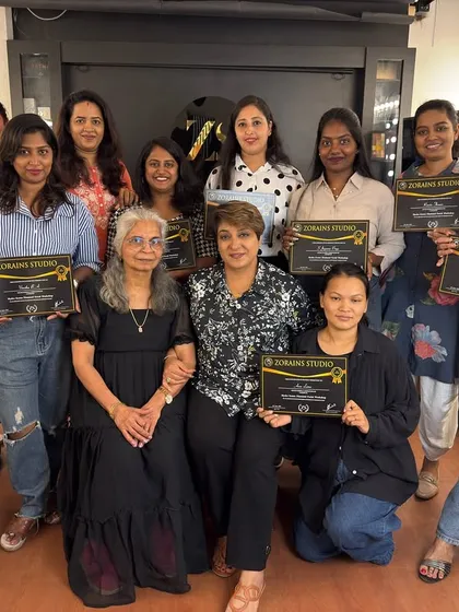 A group of proud graduates from our facial workshop, holding their certificates.