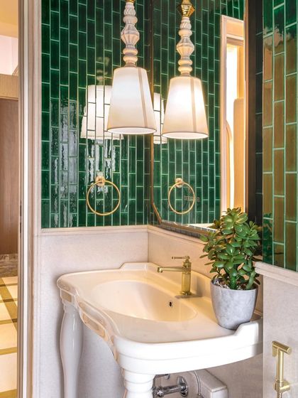 This powder room combines vintage charm with modern flair. The emerald green subway tiles, classic pedestal sink, and elegant pendant lights create a space that is both timeless and fresh.