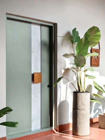 Materials tell a story. The entrance to this office features a custom door blending cool sage green with a strip of stone laminate and a warm teakwood handle. This combination creates a welcoming first impression that is serene, natural, and anything but ordinary.