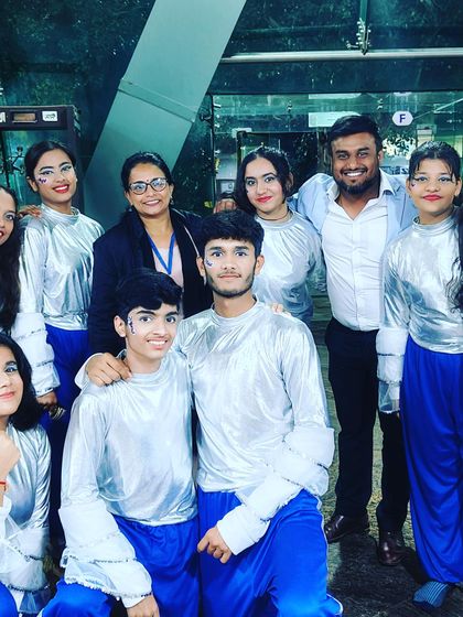 A picture with a group of boys and girls in their silver and blue costumes, showcasing another one of the diverse acts from the school festival.