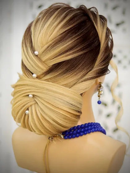 A low criss-cross bun, a perfect wedding hairstyle. I weave sections of hair over and under each other to create this intricate pattern, resulting in a very secure and elegant updo.