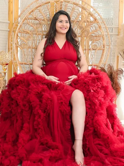 A full-length view of the dramatic red gown, showcasing its voluminous ruffled train. This is a favorite choice for moms who want a bold and beautiful look.