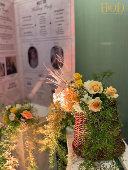 A close-up of a rustic floral arrangement in a wicker basket, part of the decor surrounding the personalized newspaper-style welcome sign.