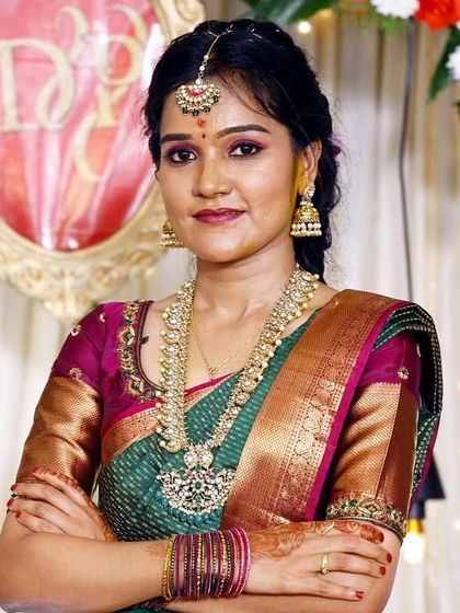A confident pose from the bride-to-be. Her traditional green and pink Kanchipuram saree is paired perfectly with the makeup and gold jewelry.