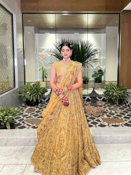 Another full-length view of the golden lehenga, showcasing its beautiful flare. The styling is perfect for a bride who wants to feel like royalty.