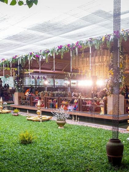 The beautiful open-air venue at Panchavati Pavilion, set for a traditional South Indian wedding with lush green lawns and elegant decor.