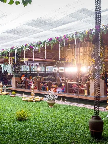 The beautiful open-air venue at Panchavati Pavilion, set for a traditional South Indian wedding with lush green lawns and elegant decor.